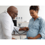 Black doctor examining pregnant patient | OBHG