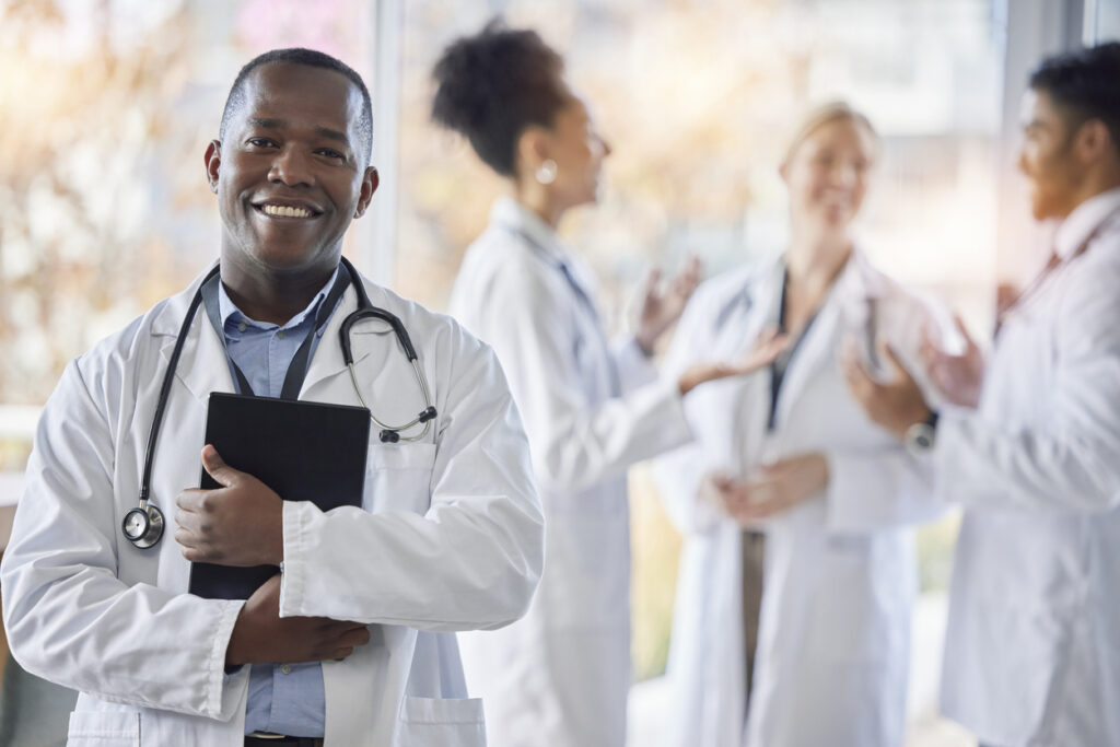black-man-doctor-portrait-and-tablet-with-medical-team-in-hospital-ready-for-healthcare-work-wellness-health-and-medic-employee-in-a-clinic-feeling-happiness-and-success-with-blurred-background