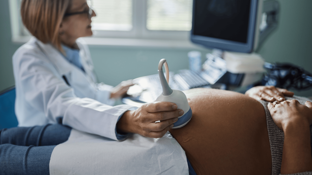 A female doctor performs an ultrasound on a pregnant woman.